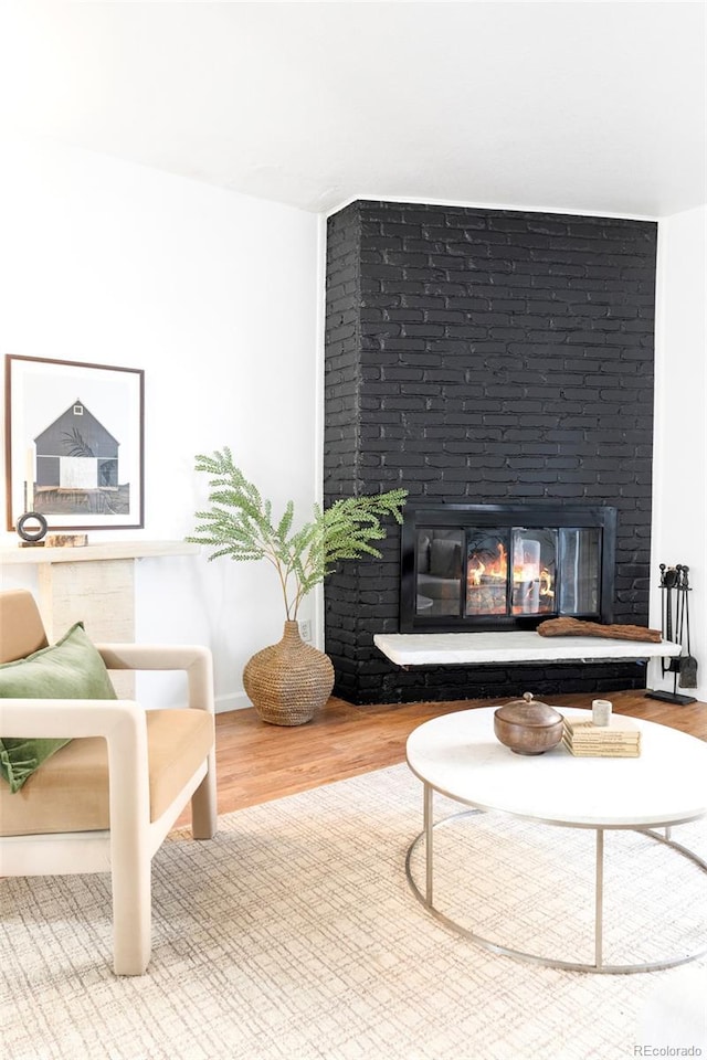 living area with a fireplace and wood finished floors