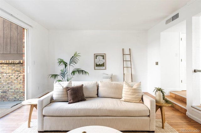 living area featuring light wood-style floors and visible vents