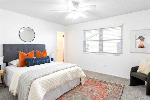 carpeted bedroom with ceiling fan, a textured ceiling, and baseboards