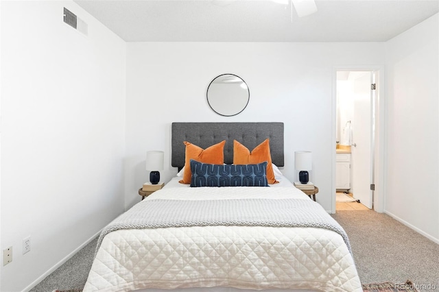 bedroom featuring carpet floors, ensuite bath, visible vents, and baseboards