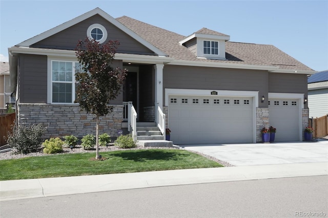 view of front facade featuring a garage, stone siding, concrete driveway, and roof with shingles