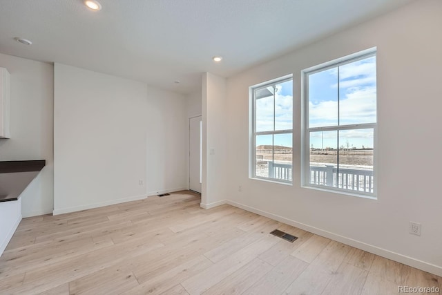 empty room featuring a water view and light wood-type flooring