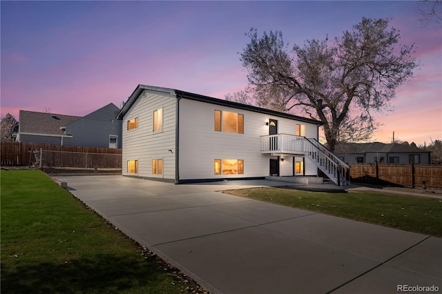 view of front of property featuring stairs, a patio, a front lawn, and fence