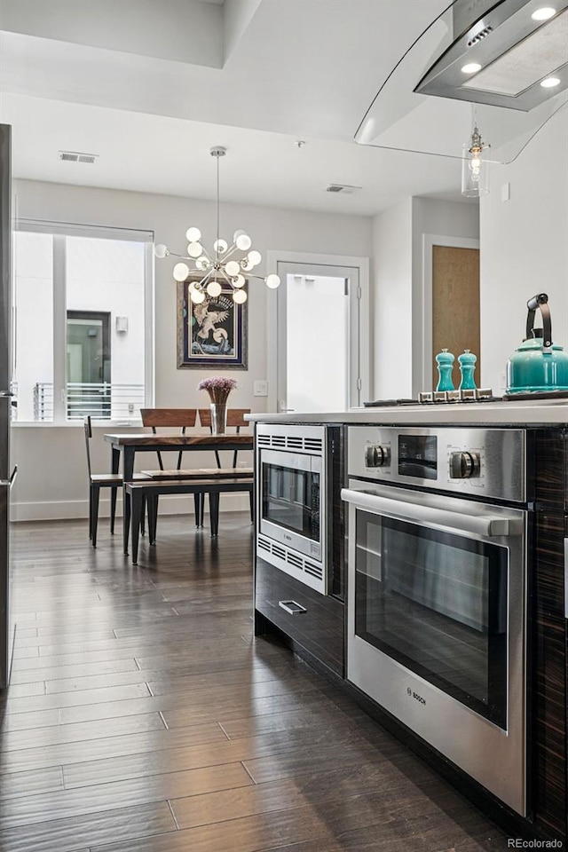 3444 Navajo St Unit 10, Denver, CO 80211 - kitchen featuring stainless steel microwave, stove, dark wood finished floors, hanging light fixtures, and a chandelier