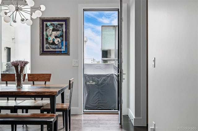3444 Navajo St Unit 10, Denver, CO 80211 - doorway to outside with a chandelier, healthy amount of natural light, baseboards, and wood finished floors