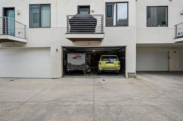 3444 Navajo St Unit 10, Denver, CO 80211 - property entrance featuring a garage, stucco siding, a balcony, and concrete driveway