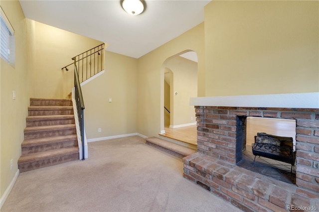 unfurnished living room with a brick fireplace and carpet flooring