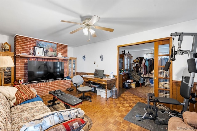 living room featuring a ceiling fan, an office area, and wainscoting
