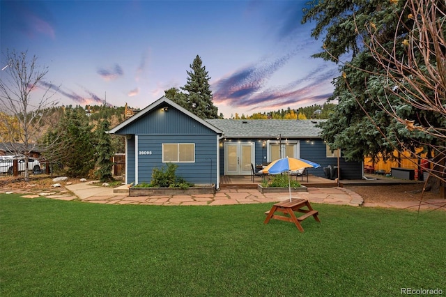 26095 Columbine Trl, Kittredge, CO 80457 - back of property at dusk featuring a lawn, french doors, and a patio area