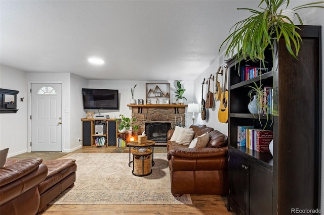 26095 Columbine Trl, Kittredge, CO 80457 - living room with a stone fireplace, baseboards, and wood finished floors
