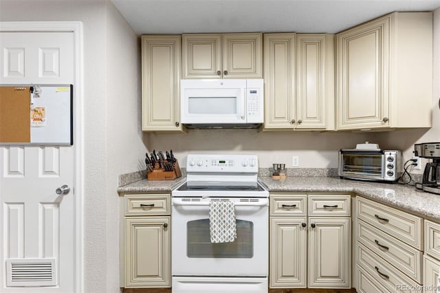 26095 Columbine Trl, Kittredge, CO 80457 - kitchen featuring light countertops, white appliances, a toaster, cream cabinetry, and visible vents