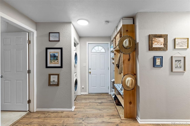 26095 Columbine Trl, Kittredge, CO 80457 - entryway with baseboards, a textured wall, stacked washer / drying machine, and light wood-style floors