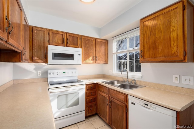 kitchen featuring sink, light tile patterned floors, and white appliances