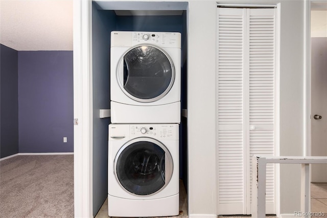 laundry area featuring light carpet and stacked washing maching and dryer