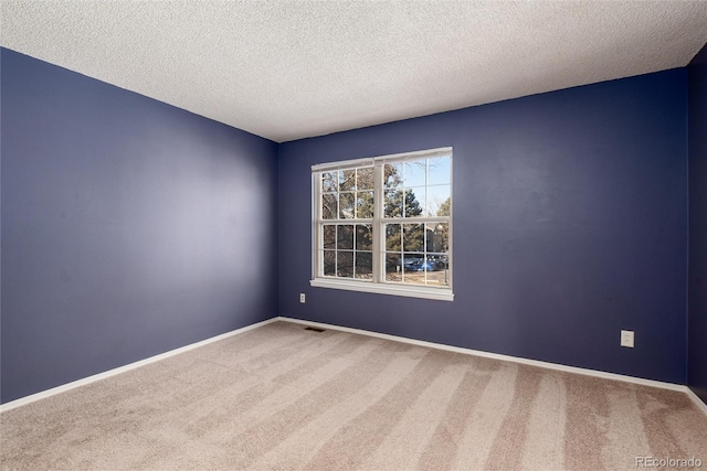 carpeted empty room with a textured ceiling