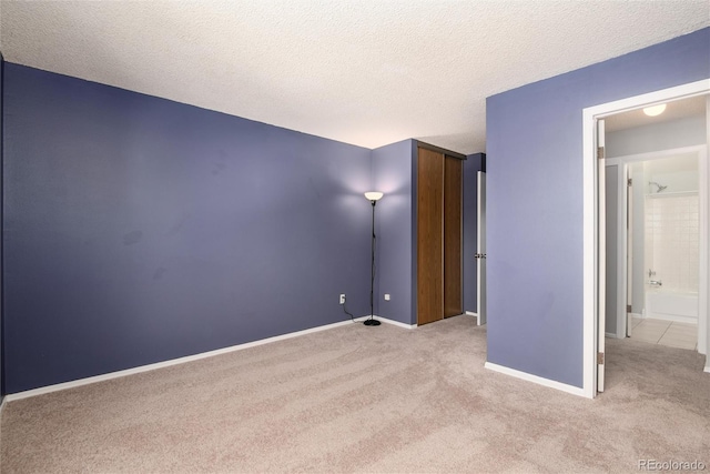 carpeted empty room with a textured ceiling