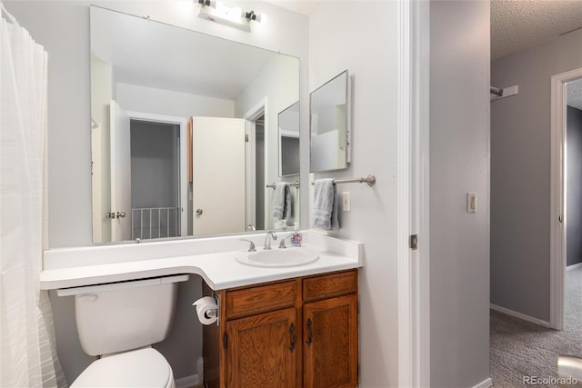 bathroom featuring vanity, a textured ceiling, and toilet