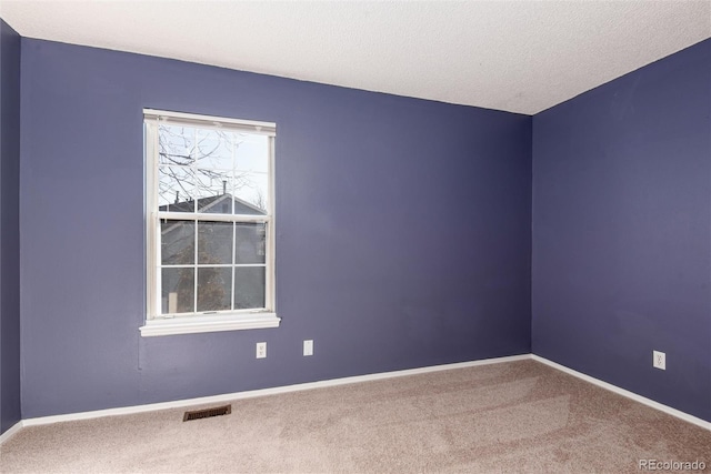 spare room featuring carpet floors and a textured ceiling