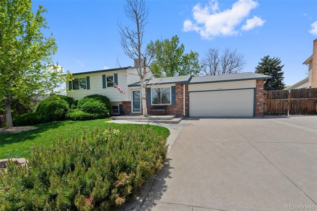 4525 S Cole Ct, Morrison, CO 80465 - split level home with driveway, an attached garage, and brick siding