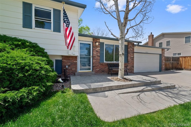 4525 S Cole Ct, Morrison, CO 80465 - view of front of property featuring driveway, fence, an attached garage, and brick siding