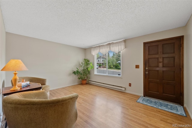 4525 S Cole Ct, Morrison, CO 80465 - sitting room featuring baseboard heating, light wood finished floors, a textured ceiling, and baseboards
