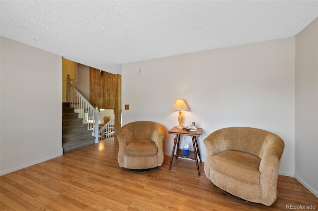 4525 S Cole Ct, Morrison, CO 80465 - sitting room with stairs, wood finished floors, a textured ceiling, and baseboards