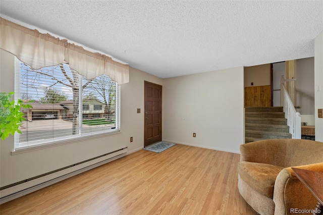 4525 S Cole Ct, Morrison, CO 80465 - sitting room with baseboard heating, a textured ceiling, light wood finished floors, stairs, and baseboards