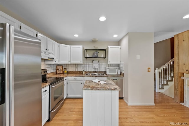 4525 S Cole Ct, Morrison, CO 80465 - kitchen featuring stainless steel appliances, a sink, under cabinet range hood, a kitchen island, and white cabinets
