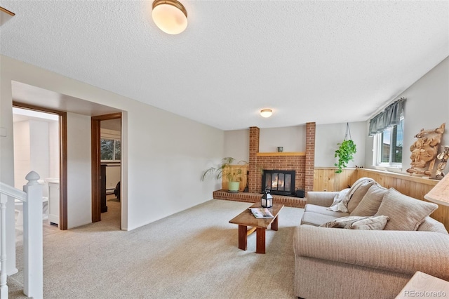 4525 S Cole Ct, Morrison, CO 80465 - carpeted living room featuring a textured ceiling, wainscoting, wood walls, and a brick fireplace