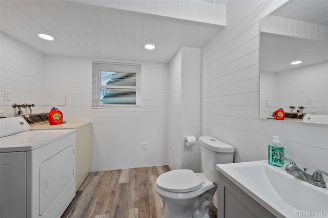 4525 S Cole Ct, Morrison, CO 80465 - bathroom with washer and clothes dryer, wood finished floors, toilet, vanity, and wooden walls