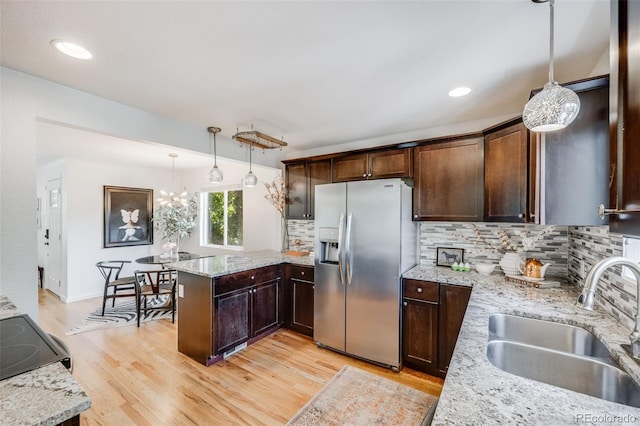 1765 Xenia St, Denver, CO 80220 - kitchen with stainless steel fridge with ice dispenser, a sink, decorative backsplash, a peninsula, and recessed lighting