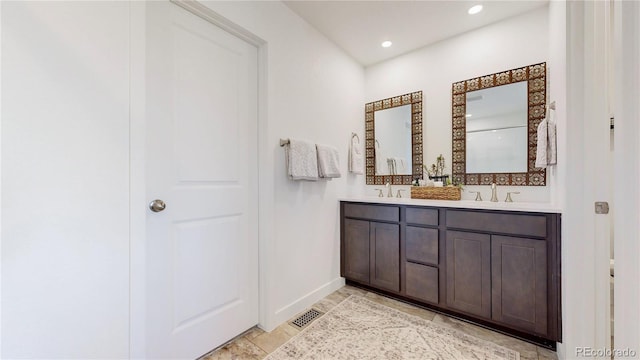 689 Olive St, Broomfield, CO 80023 - bathroom with visible vents, baseboards, a sink, double vanity, and recessed lighting