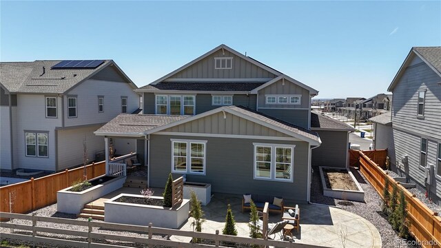 689 Olive St, Broomfield, CO 80023 - back of house featuring a garden, board and batten siding, a patio, fence private yard, and roof with shingles