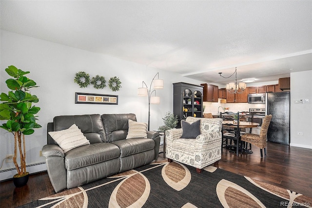 living room featuring a baseboard radiator, dark wood-style flooring, and a notable chandelier