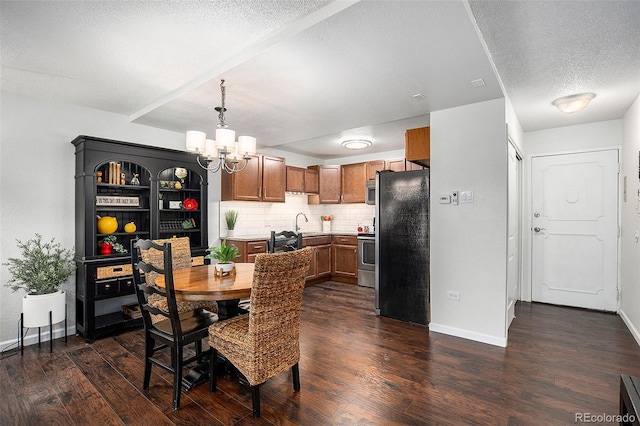 dining area featuring a textured ceiling, dark hardwood / wood-style flooring, sink, and a chandelier