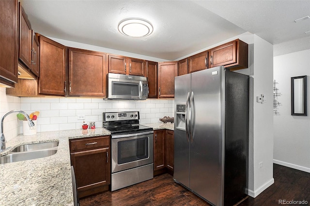 kitchen featuring dark hardwood / wood-style flooring, sink, light stone countertops, and stainless steel appliances