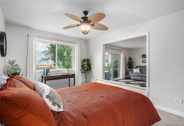 bedroom featuring carpet floors, a textured wall, ceiling fan, a textured ceiling, and baseboards