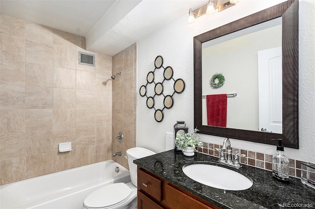 full bathroom featuring a textured ceiling, vanity, tiled shower / bath combo, and toilet