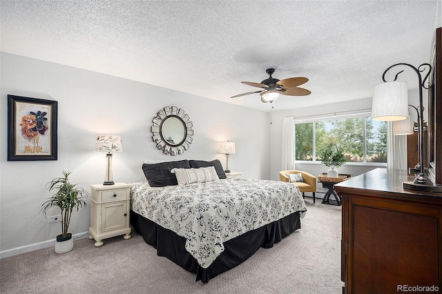 bedroom with baseboard heating, light colored carpet, a textured ceiling, and baseboards