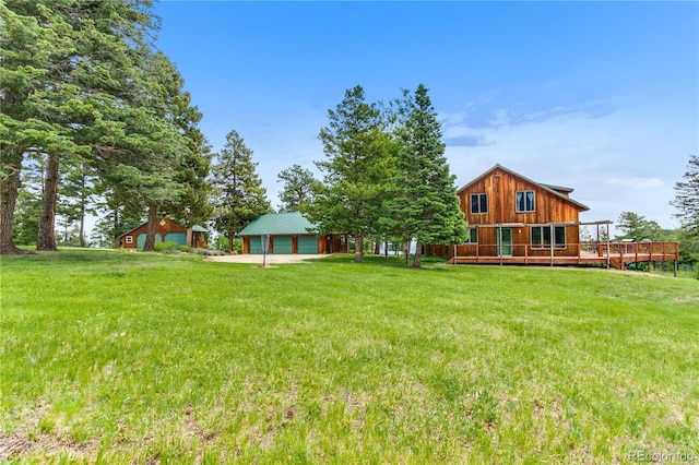 8834 Deiffendeffer Rd, Rye, CO 81069 - view of grassy yard featuring a detached garage, a deck, an outbuilding, and driveway