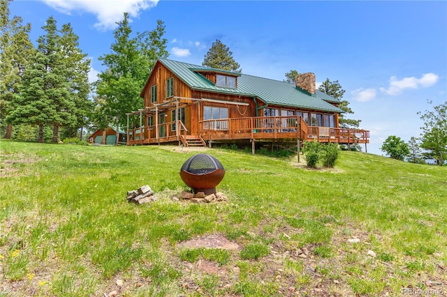 8834 Deiffendeffer Rd, Rye, CO 81069 - back of house featuring a chimney, a wooden deck, a metal roof, a lawn, and a standing seam roof