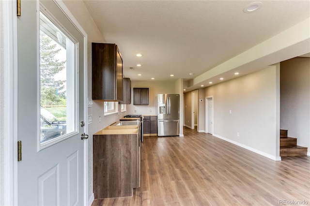 8834 Deiffendeffer Rd, Rye, CO 81069 - kitchen featuring stainless steel fridge, light wood finished floors, recessed lighting, dark brown cabinetry, and light countertops