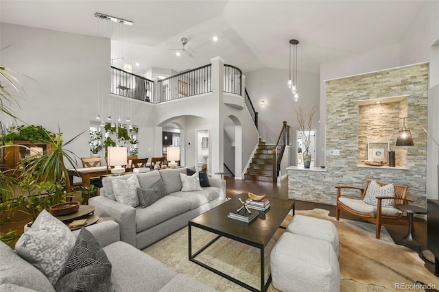 10793 Alcott Way, Denver, CO 80234 - living area featuring arched walkways, stairway, a ceiling fan, and high vaulted ceiling