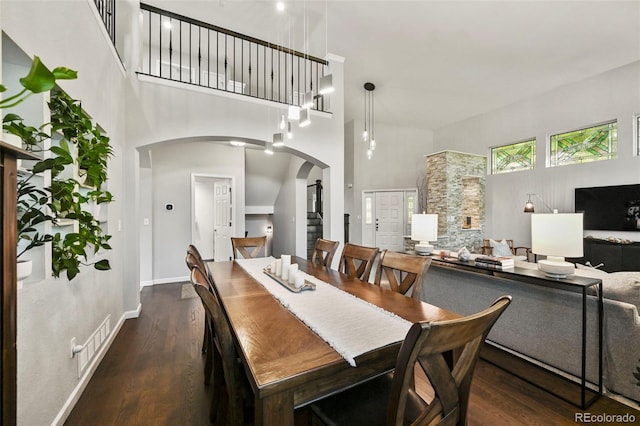 10793 Alcott Way, Denver, CO 80234 - dining space featuring arched walkways, a high ceiling, and wood finished floors