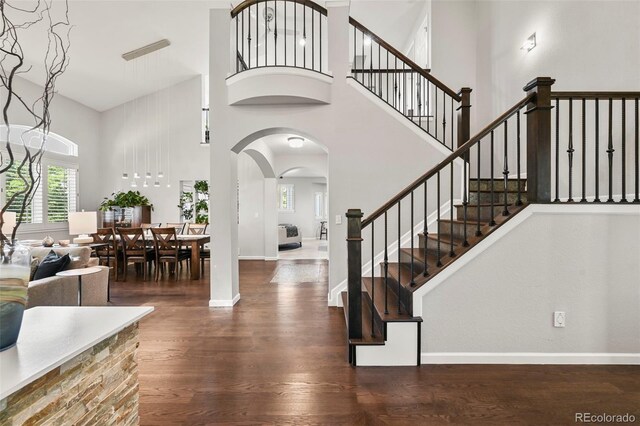 10793 Alcott Way, Denver, CO 80234 - foyer featuring a high ceiling, arched walkways, wood finished floors, and stairs