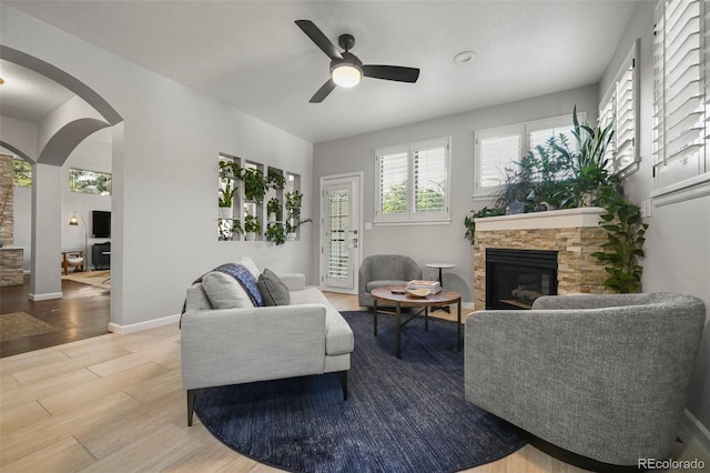 10793 Alcott Way, Denver, CO 80234 - living area with a fireplace, a ceiling fan, wood finished floors, and arched walkways
