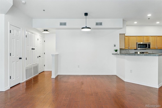 kitchen with stainless steel microwave, recessed lighting, visible vents, and wood finished floors