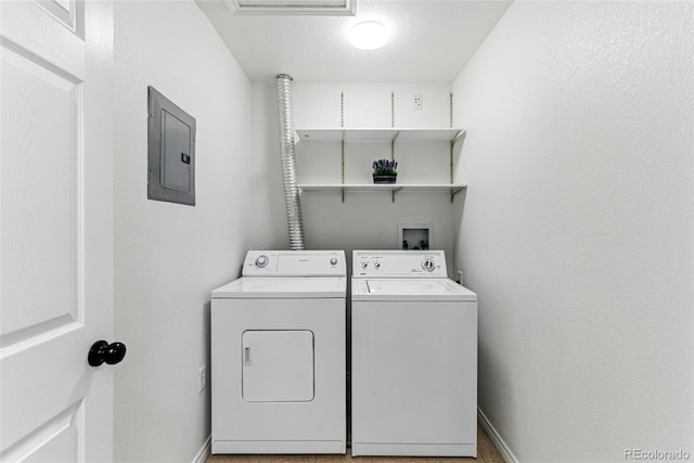 washroom featuring electric panel, baseboards, separate washer and dryer, and laundry area