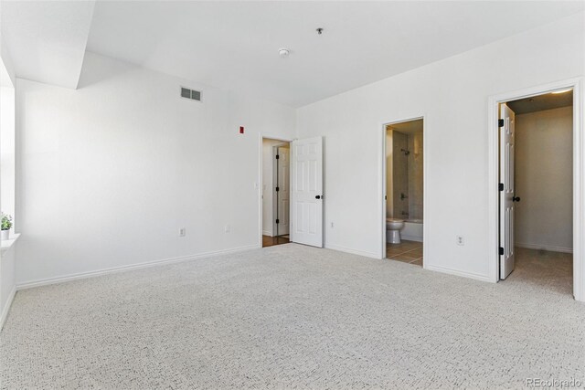 unfurnished bedroom with visible vents, carpet floors, baseboards, and ensuite bath