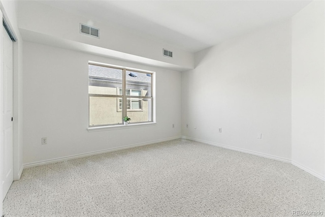 empty room with baseboards and visible vents